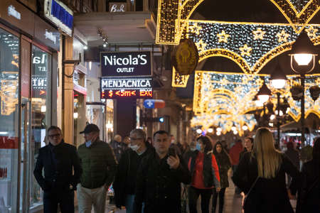 BELGRADE, SERBIA - NOVEMBER 11, 2020: Crowd of people, mainly men, some blurred, wearing a respiratory face mask in the streets of Belgrade.のeditorial素材