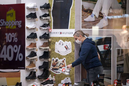 BELGRADE, SERBIA - NOVEMBER 11, 2020: Employee of a shoe store footwear boutique standing alone around shoes wearing a respiratory face mask in Belgrade.のeditorial素材