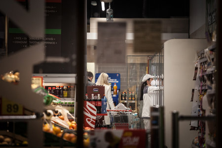 BELGRADE, SERBIA - NOVEMBER 13, 2020: female staff, worker of a supermarket retail shop wearing a...