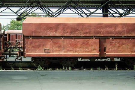Open hopper car wagon on standby at the platform of a train station in a cargo train shipping nickel and other mineral ore.の写真素材