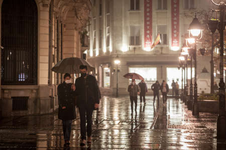 BELGRADE, SERBIA - NOVEMBER 5, 2020: Young couple, lovers, man and woman wearing a face mask in the streets of Kneza Mihailovaのeditorial素材