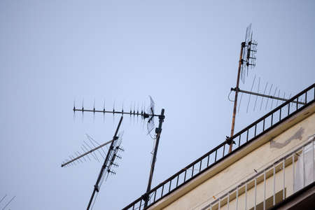 Television antennas, VHF and UHF frequencies, at the top of a European roof. VHF and UHF are two of the main TV transmission and reception systems.の写真素材