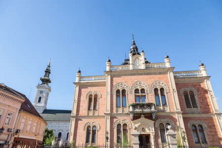 Facade of Vladicanski Dvor, the Bishop Episcopal palace of Novi Sad, Serbia, with its typical Austro hungarian architecture, with the Saborna crkva church, an Orthodox cathedral, in the background.のeditorial素材