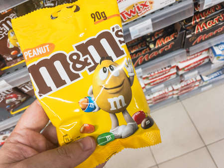 BELGRADE, SERBIA - JULY 4, 2021: M & M's logo on a pack of peanut flavored dragees. M & Ms is a brand of Mars company producing candy shell chocolates, multicolor, with various flavors.のeditorial素材