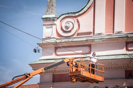 LJUBLJANA, SLOVENIA - JUNE 15, 2021: Selective blur on an electrician, a technician worker fixing...
