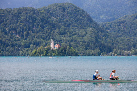 BLED, SLOVENIA - JUNE 13, 2021: Two young female adults, rowers, on a coxless pair four, a rowing...
