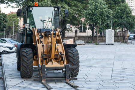 Selective blur on a yellow forklift truck, industrial big size, on display in an outdoor construction site used at moving, loading and unloading construction materials.の写真素材