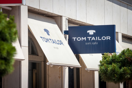 LJUBLJANA, SLOVENIA - JUNE 13, 2021: Tom Tailor logo in front of their shop for Ljubljana. Tom Tailor is a german chain of Fashion retailers of clothing spread worldwide.のeditorial素材