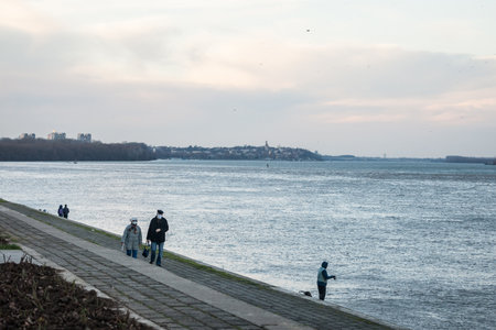 BELGRADE, SERBIA - JANUARY 2, 2021: Old senior man and woman, couple, wearing a facemask, waking in front of danube river in winter of Belgrade.のeditorial素材