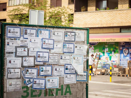 MLADENOVAC, SERBIA - APRIL 30, 2021: Death notices (umrlice) posted on a billboard in the city center of Mladenovac, indicating the recent deceased persons in a region plagued with demographic decline.のeditorial素材