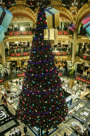 PARIS, FRANCE - DECEMBER 24, 2010: Galeries Lafayette christmas tree, in the interior of the building, with a crowd by boutiques. Also called Christmas tree, it's a symbol of the department store for holidays.のeditorial素材