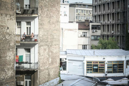 BELGRADE, SERBIA - SEPTEMBER 11, 2014: Selective blur on a young couple, lovers, on a balcony during a warm summer afternoon in a decayed and neglected residential building.のeditorial素材