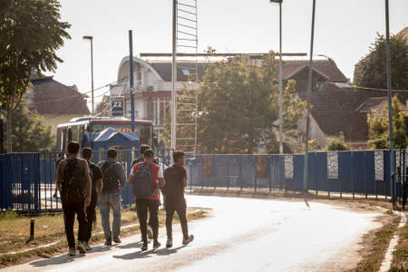 OBRENOVAC, SERBIA - AUGUST 15, 2021: Young afghani refugees from Afghanistan, men, walking to a bus station to take transportation while escaping the afghani conflict, on Balkans Route, on refugees crisis.のeditorial素材