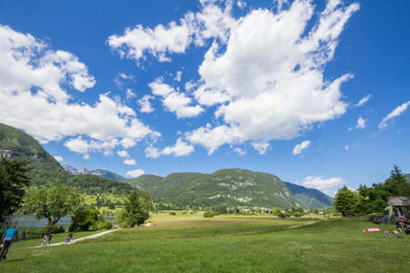 BOHINJ, SLOVENIA - JUNE 13, 2021: People passing by the beach of Stara Fuzina over Lake Bohinj, also called bohinjsko jezero, on a sunny afternoon. Bohinj lake is a landmark of the Julian Alps mountain.のeditorial素材