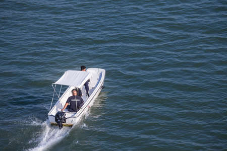 SREMSKA MITROVICA, SERBIA - AUGUST 8, 2021: Serbian border police officers in uniform patrolling on the Sava river on a boat, belonging  to the civilian police force of the country, known as Policija.のeditorial素材