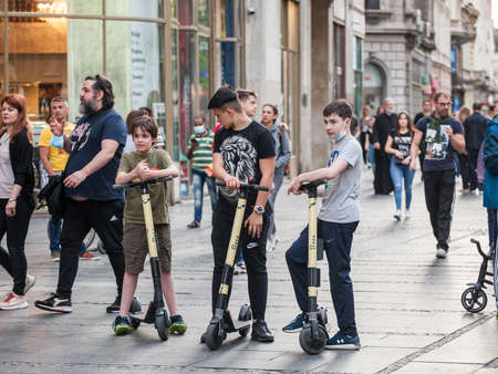 BELGRADE, SERBIA - MAY 27, 2021: group of youngsters, male boy kids, standing with an electric...