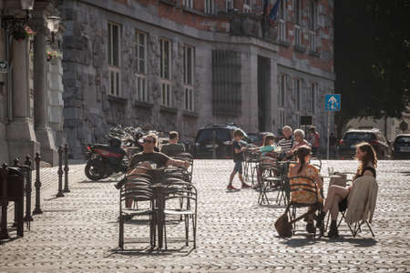 LJUBLJANA, SLOVENIA - JUNE 15, 2021: Selective blur on a patio of a cafe restaurant at half capacity with people sitting, respecting social distancing, in the city center of Ljubljana.のeditorial素材