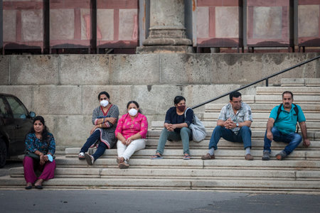 BELGRADE, SERBIA - AUGUST 12, 2021: Indian tourists, male and female middle aged from india, sitting in a belgrade street while travelling, some wearing a face mask on Coronavirus Covid 19 crisis.のeditorial素材