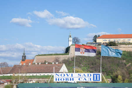 NOVI SAD, SERBIA - MARCH 26, 2017: Flags of Novi sad and Serbia in front of Petrovaradin Fortress, on a sunny winter afternoon. It is one of the main landmarks and monuments of the capital city of Voivodinaのeditorial素材