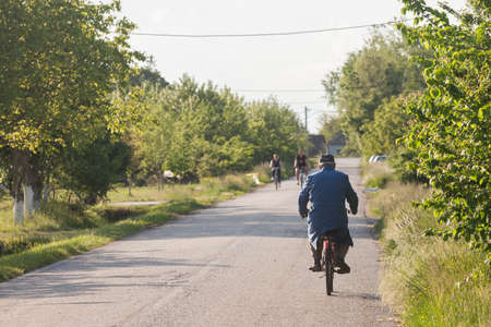 RITISEVO, SERBIA - MAY 16, 2021: Old senior man riding a bicycle, biking on the rural countryside roads of Vojvodina, the most agricultural part of serbia, plagued with demographic decline.のeditorial素材