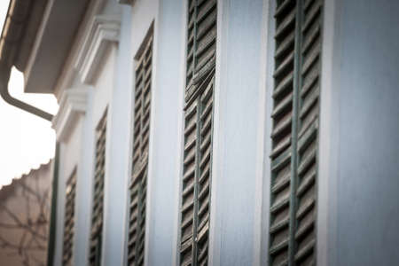 Selective blur on closed wooden blinds and blinders on windows on the ground floor of a house, a residential building, in the city center of Belgrade, the capital city of Serbia, during a sunny afternoon.の写真素材