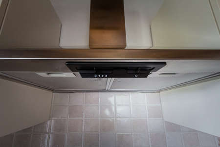 Selective blur on a cooker hood on a brand new kitchen, in stainless steel. Also called kitchen hood or range fan, it is used in kitchen to ventilate and extract fumes and cooking smells.の写真素材
