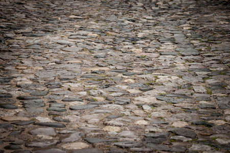 Selective blur on an Old cobblestone pavement made of granite. Cobblestone used to be a covering for...