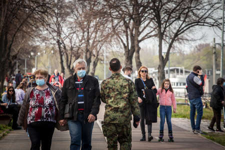 BELGRADE, MARCH 27, 2021: Selective blur on Old senior man and woman, couple, wearing a facemask, waking in street of Belgrade in spring during  coronavirus covid 19 health crisis.のeditorial素材
