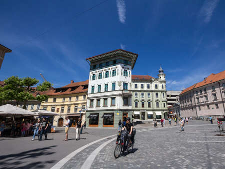 LJUBLJANA, SLOVENIA - JUNE 17, 2021: Woman cycling with her city bik on Presernov trg square, in downtown Ljubljana, one of the most car free capitals of Europe.のeditorial素材
