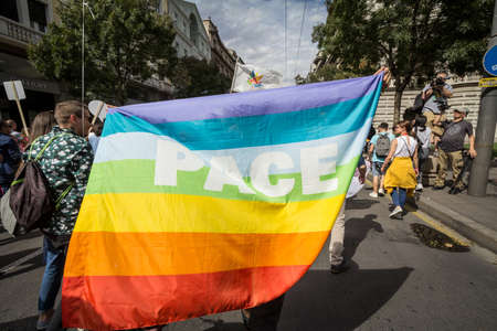 BELGRADE, SERBIA - SEPTEMBER 17, 2017: protestors holding a giant Pace (peace in italian) rainbow gay flag during the 2017 Belgrade Gay Pride, happy and smiling The parade happened this year without trouble.のeditorial素材