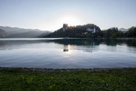 Panorama of the Bled lake, Blejsko Jezero, with its castle, Blejski Hrad, during a sunny sunset in summer with the mountains of Julian alps. Bled Castle is a major monument of Slovenia.のeditorial素材