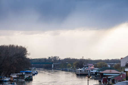 Panorama of Tamis river, on Pancevo Waterfront in city center during a rainy afternoon with boats and typical rafts, called spalv or splavovi on the quay. Pancevo is the main city of Banat, Serbia.のeditorial素材