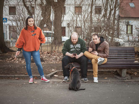 BELGRADE, SERBIA - JANUARY 27, 2017: Young people, generation Y men and women, sitting on a bench...