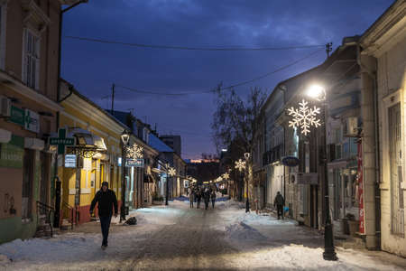 PANCEVO, SERBIA - JANUARY 23, 2021: Selective blur on people walking in the snow on the main street of Pancevo, Njegoseva ulica, during a winter snowy night in Banat region.のeditorial素材