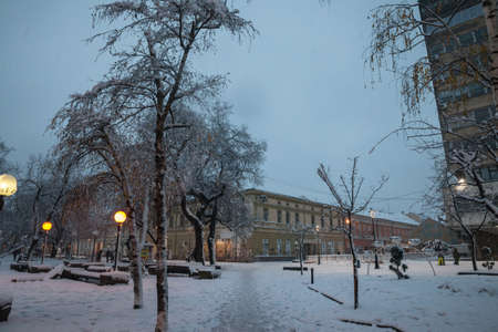 PANCEVO, SERBIA - DECEMBER 12, 2021: Selective blur on people walking in the snow between the main...