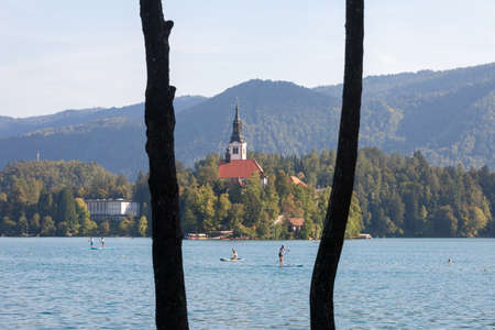 BLED, SLOVENIA - JUNE 12, 2021: Selective blur on People doing paddleboarding near the Blejsko...