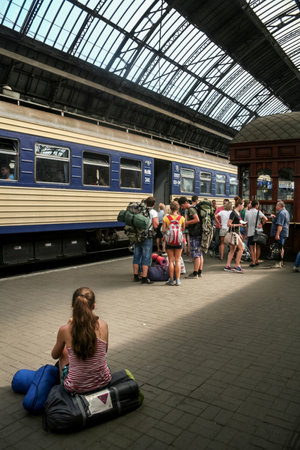 LVIV, UKRAINE - AUGUST 11, 2014: People, mainly women, waiting to board a train from ukrzaliznytsia, the ukrainian railways, on the platforms of Lviv train station.のeditorial素材