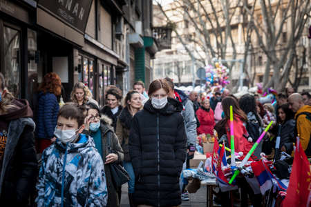 BELGRADE, SERBIA - JANUARY 1, 2022: Selective blur on a Woman, young, walking in a crowd wearing face maskのeditorial素材