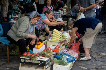 LVIV, UKRAINE - AUGUST 13, 2014: Group of females, Group of senior old women, babusha, selling food,...