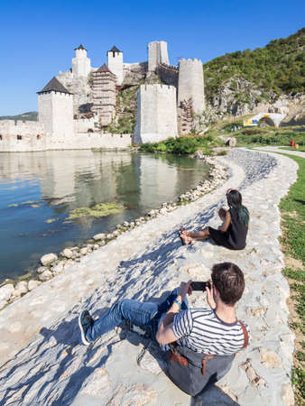 GOLUBAC, SERBIA - SEPTEMBER 16, 2017: Selective blur on a couple of lovers taking pictures in front of Golubac Fortress (Golubacka trvdjava, or Goluback Grad), a medieval castle by danube river.のeditorial素材