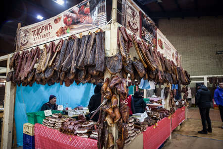 KACAREVO, SERBIA - MARCH 6, 2022: Selective blur on a Stand of a butcher in the Slaninijada Kacarevo market selling smoked and cured meat, as well as dried pork, also called suvo meso in Serbian.のeditorial素材