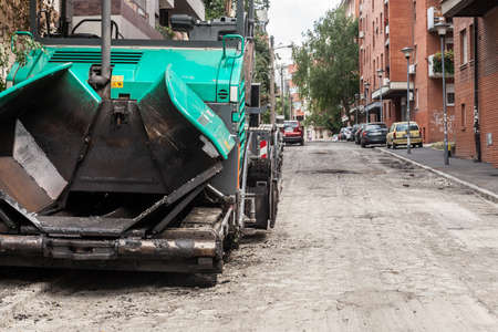 BELGRADE, SERBIA - JULY 4, 2021: Selective blur on an sphalt spreader machine, or road paver on display during a road renovation in belgrade, used to put asphalt on a street in urban environment.のeditorial素材