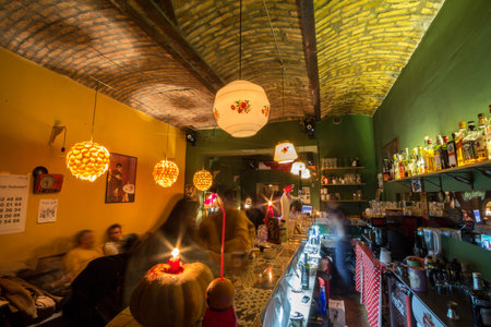 BELGRADE, SERBIA - OCTOBER 10, 2017: Selective blur on a bar counter inside a belgrade cafe and bar at night with a speed blur on clients passing and consuming coffee and alcohol.のeditorial素材