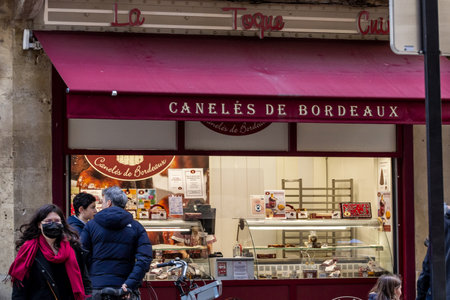 BORDEAUX, FRANCE - FEBRUARY 19, 2022: Selective blur on a pastry shop cooking and selling Canneles Bordelais, a traditional pastry from bordeaux.のeditorial素材