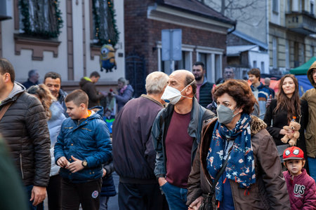 BELGRADE, JANUARY 1, 2022: Selective blur on Old senior man and woman, couple, wearing a facemask, waking in street of Belgrade in winter during  coronavirus covid 19 health crisis.のeditorial素材