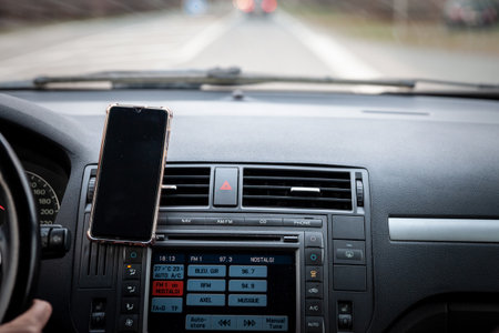 BORDEAUX, FRANCE - FEBRUARY 20, 2022: Selective blur on a smartphone with a phone holder on the control panel of a car,used for GPS Navigation and orientation in a car.のeditorial素材