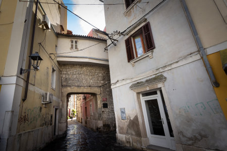 PIRAN, SLOVENIA - SEPTEMBER 17, 2021: Typical mediterranean old narrow street with southern european architecture, with ancient buildings, in the old town of piran or Pirano, in Slovenia, a city of Istria, on Adriatic sea.のeditorial素材