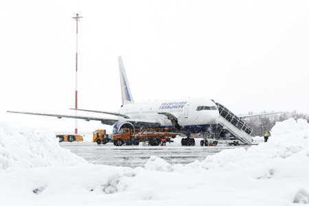 PETROPAVLOVSK, KAMCHATKA, RUSSIA - MARCH 19, 2015: Technical and service support airfield maintenance airplane Boeing-767 Transaero Airlines at airport of Petropavlovsk-Kamchatsky City (Elizovo airport) during a snowfall and poor visibility.のeditorial素材