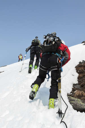 AVACHA VOLCANO, KAMCHATKA, RUSSIA - APRIL 21, 2012: Open Cup of Russia on ski-mountaineering on the Kamchatka. Team ski mountaineers climbing on the rock on a rope with skis strapped to a backpack.のeditorial素材