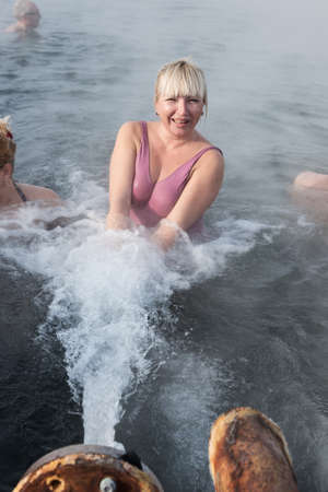 KAMCHATKA PENINSULA, RUSSIA - FEB 02, 2013: Satisfied woman relaxing in geothermal spa in hot spring pool in the winter. Eurasia, Russian Far East, Kamchatsky Krai, Anavgay Village.のeditorial素材